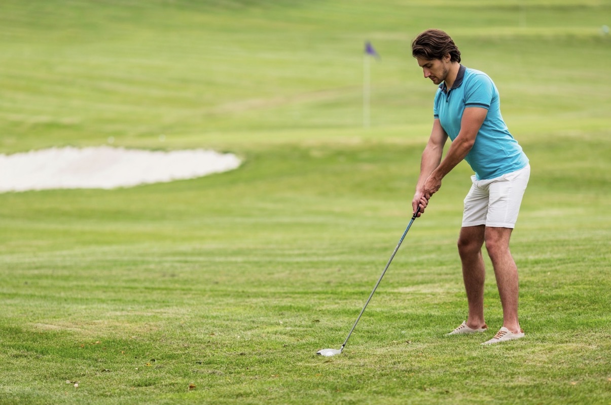 Golfer checking iron flight distance on practice range