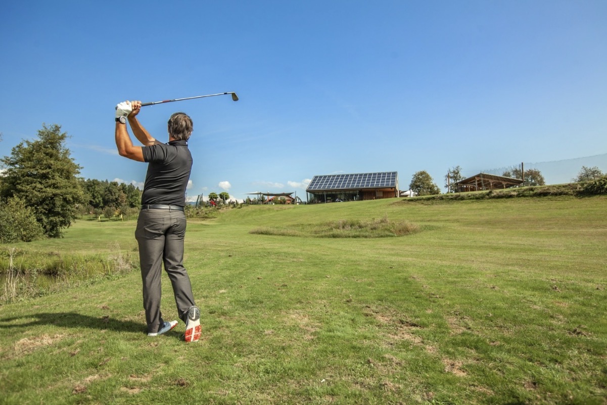 Golfer practicing chipping and putting on practice green